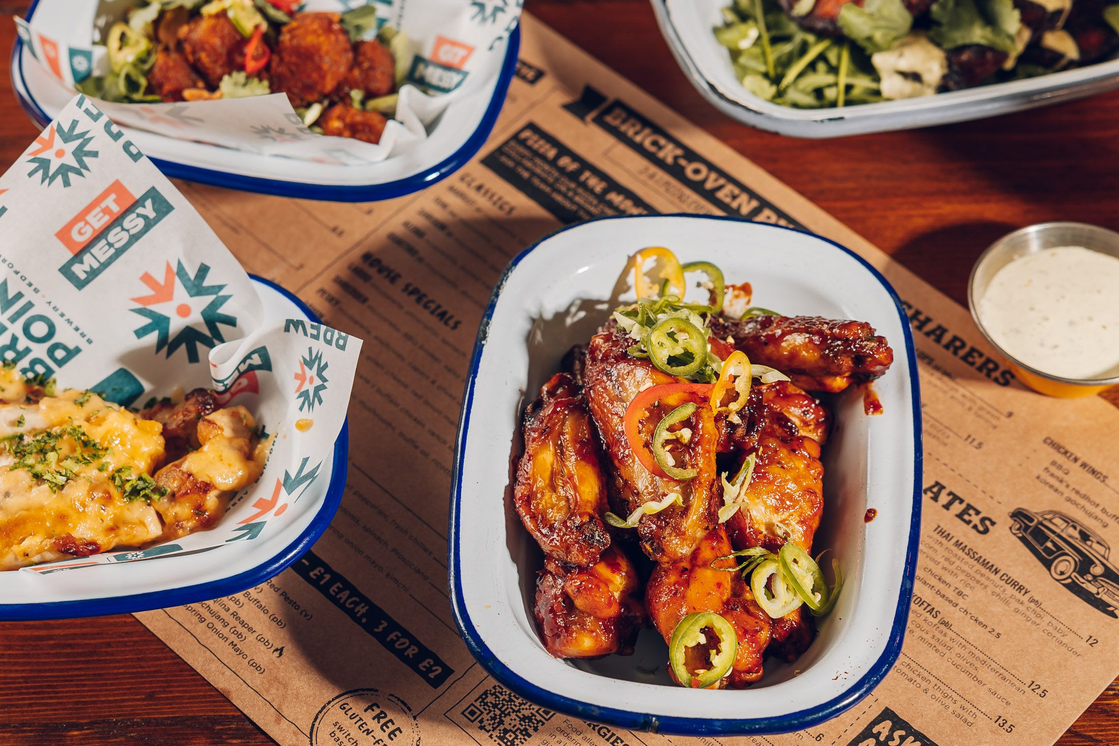 Table with tapas style dishes including chicken wings