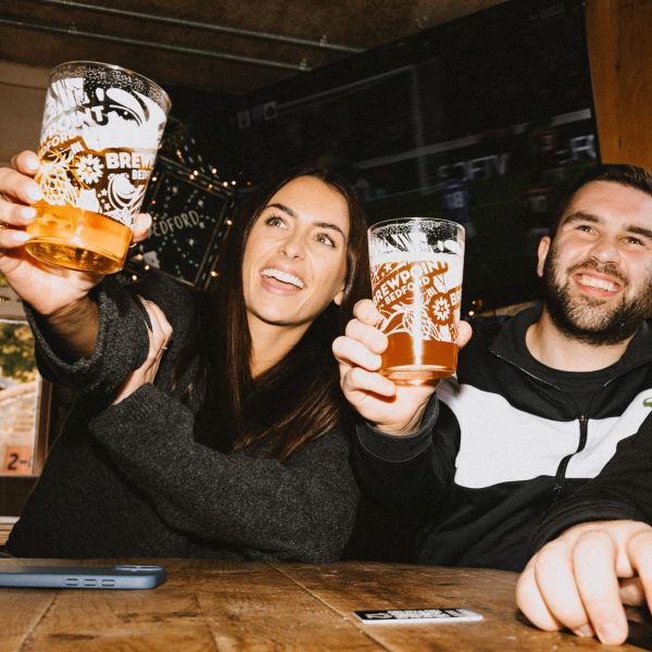 Two sports fans lifting their free beer from Matchday club